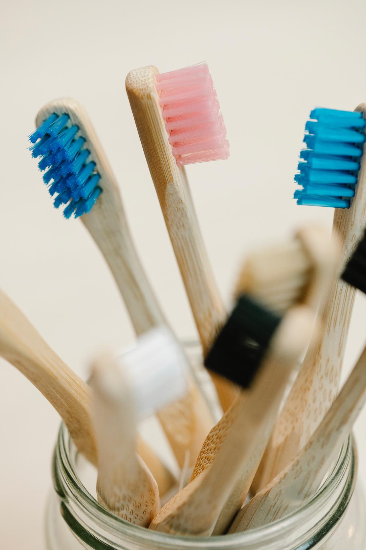 Up close jar of pink, blue, etc toothbrushes - Photo by Sarah Chai from Pexels