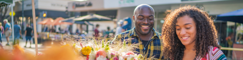 A black man and woman shop at Farmers Market