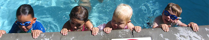 a line of kids taking a swim lesson at the swim center