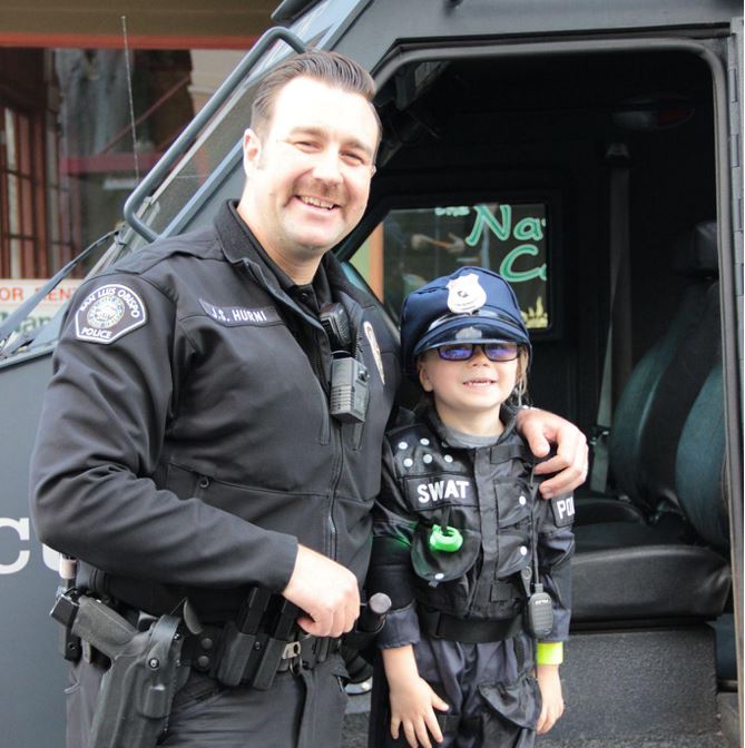 Officer with a child wearing a kids SWAT uniform