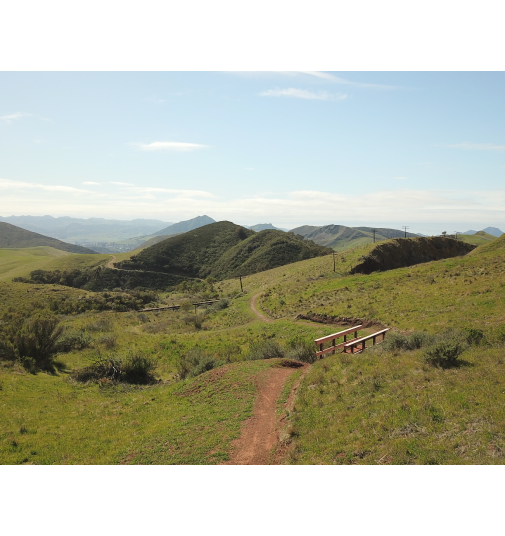 hike trail of miossi with green hills and blue skies