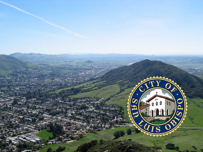 Aerial photo of San Luis Obispo city surrounded by green hills.