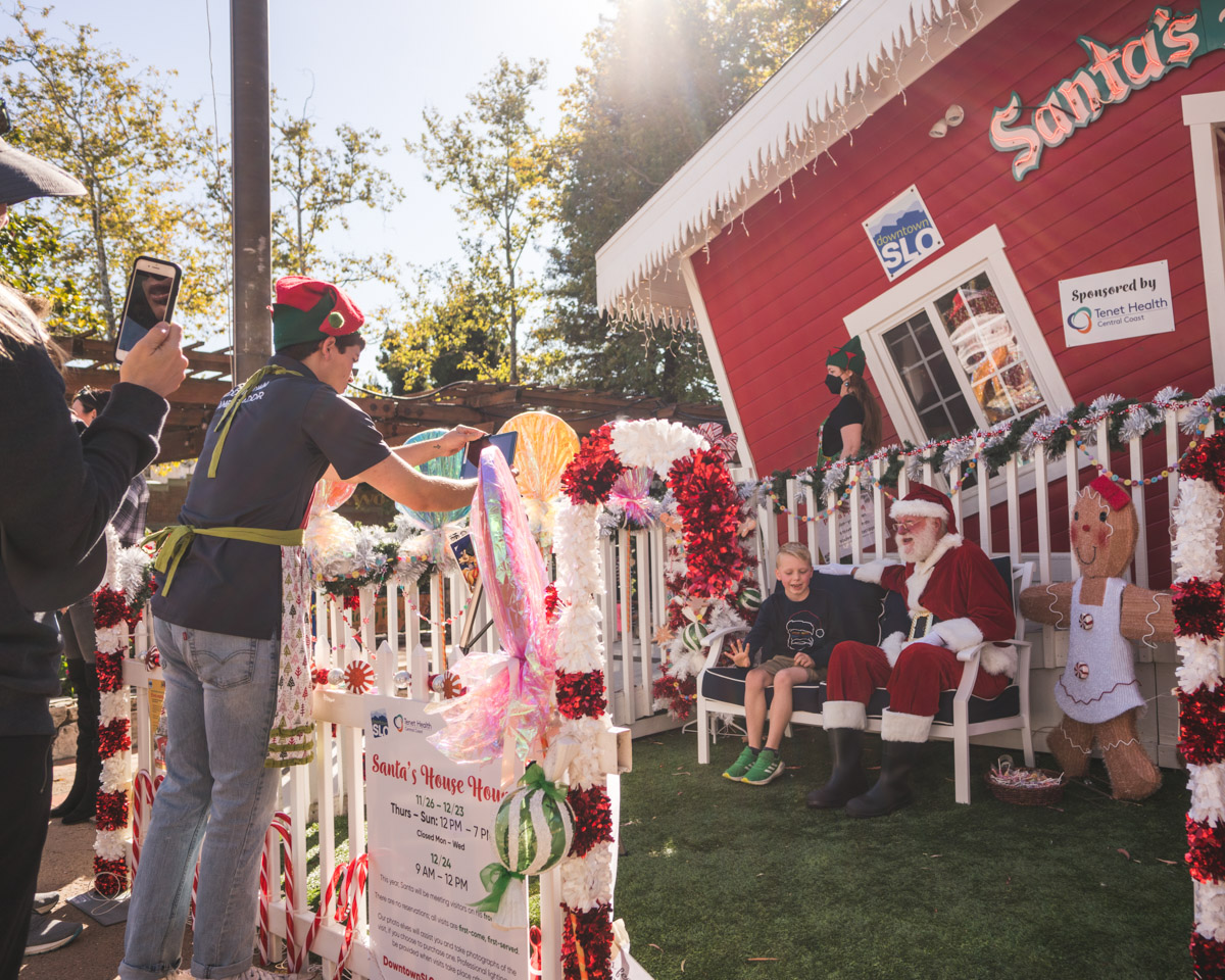 Elves take photos of kids with Santa.