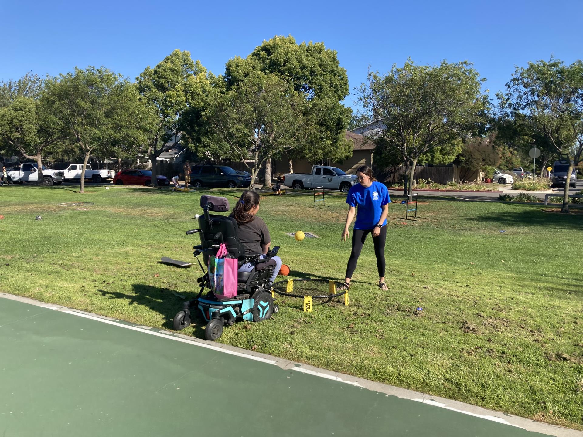 A child playing at the park with a SLO Parks & Recreation staff member