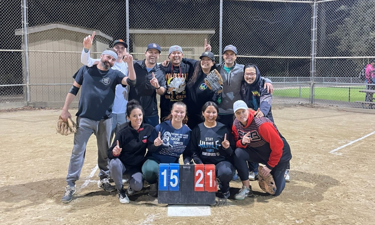 A co-ed adult softball team celebrating a win