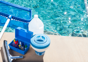 Pool cleaning tools sitting beside pool