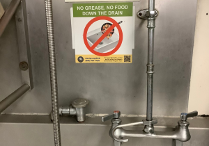 No grease down the drain sticker on restaurant kitchen sink