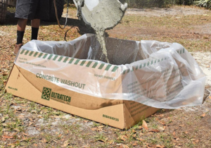 Concrete truck chute being washed into a plastic lined washout bin