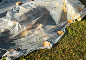 Construction wood covered with plastic sheeting and sandbags