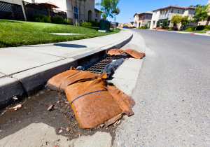 Storm drain inlet protected with filter fabric and sandbags on either side