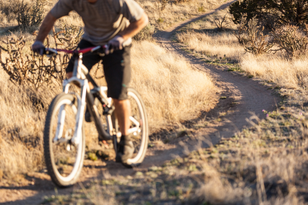 A close up picture of a person riding their bike on a dry bike trail