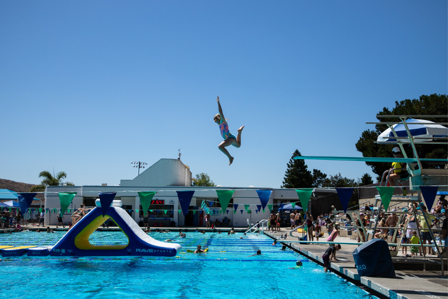 A picture of a youth jumping off the diving board at the SLO Swim Center during Super Rec Saturdays in the summer of 2023