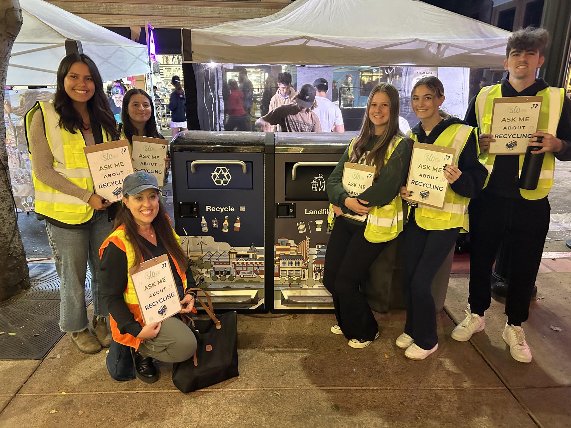 Several volunteers join a city staff member to help raise awareness about recycling.