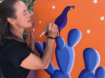 A picture of artist Sally painting a San Luis Obispo Art Box