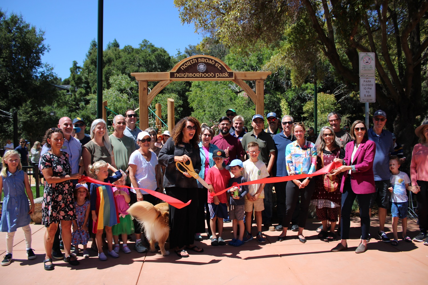 Community members and city officials gather in front of the North Broad Street Neighborhood Park for a ribbon cutting ceremony.