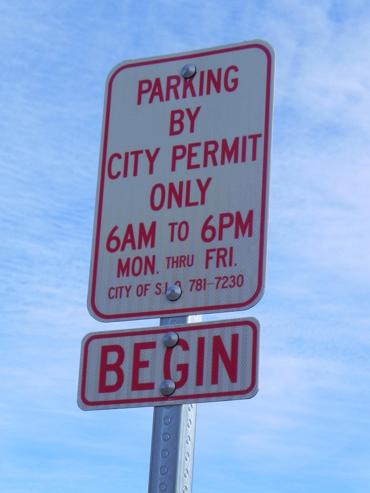 photo of red and white city parking sign