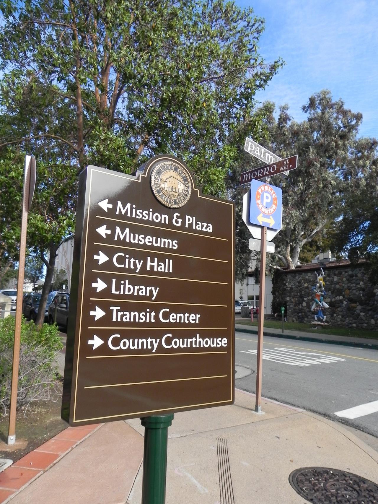 brown sign directing to various city buildings