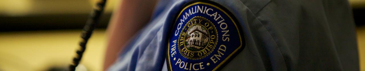 closeup image of an officer with a communications, fire, police, and EMD patch