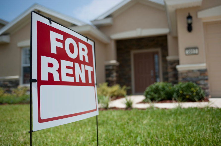 house with "For rent" sign infront 